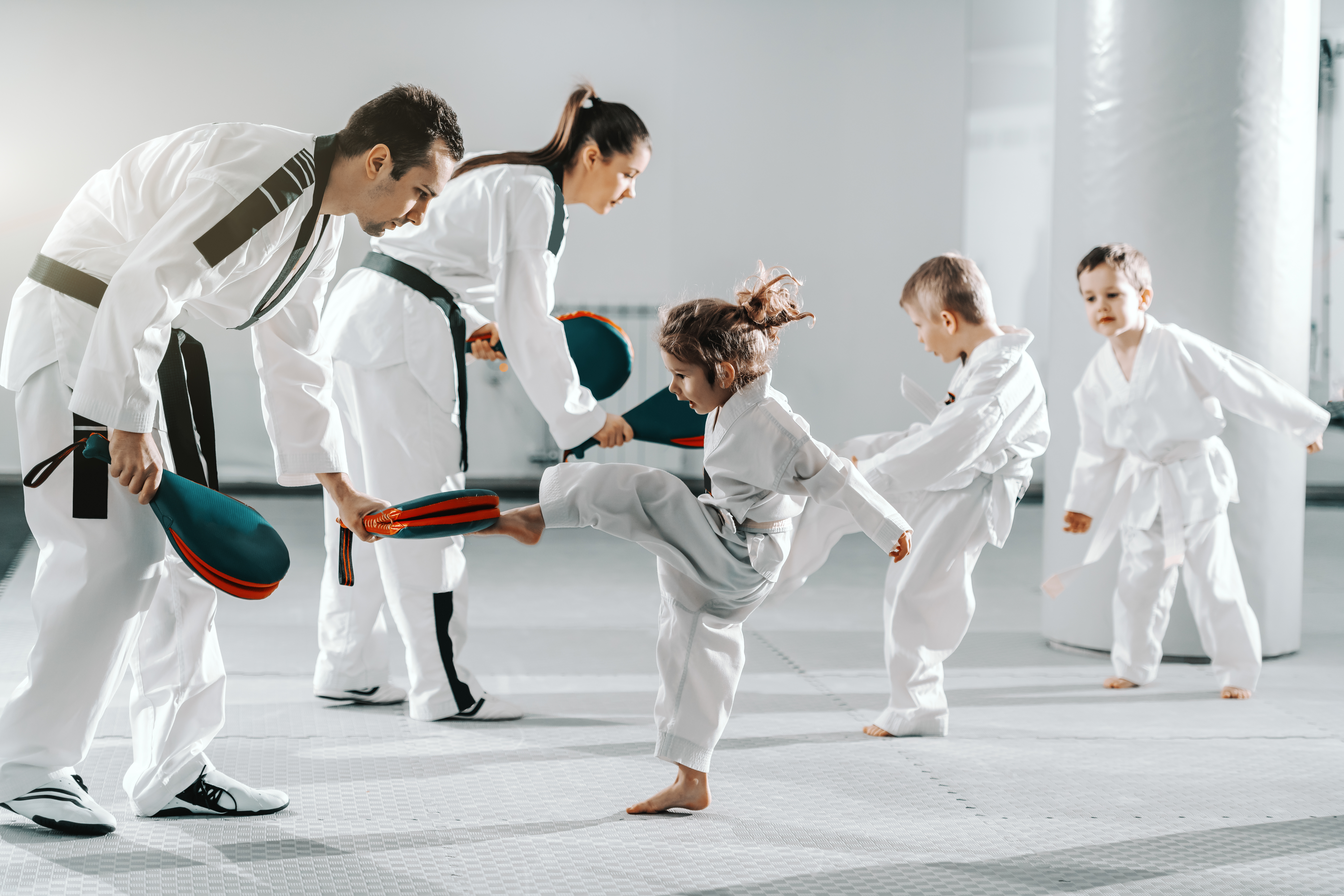 Instructor guiding young students through kicking drills