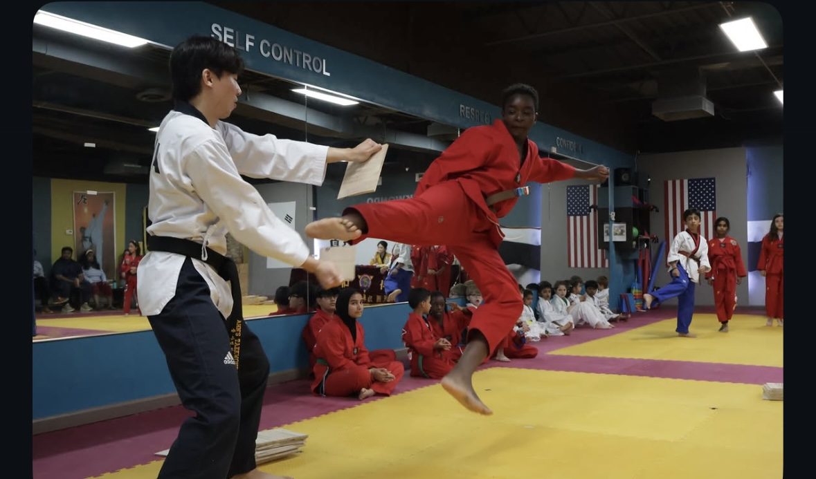Ahn's Taekwondo student breaking a board with a jumping kick