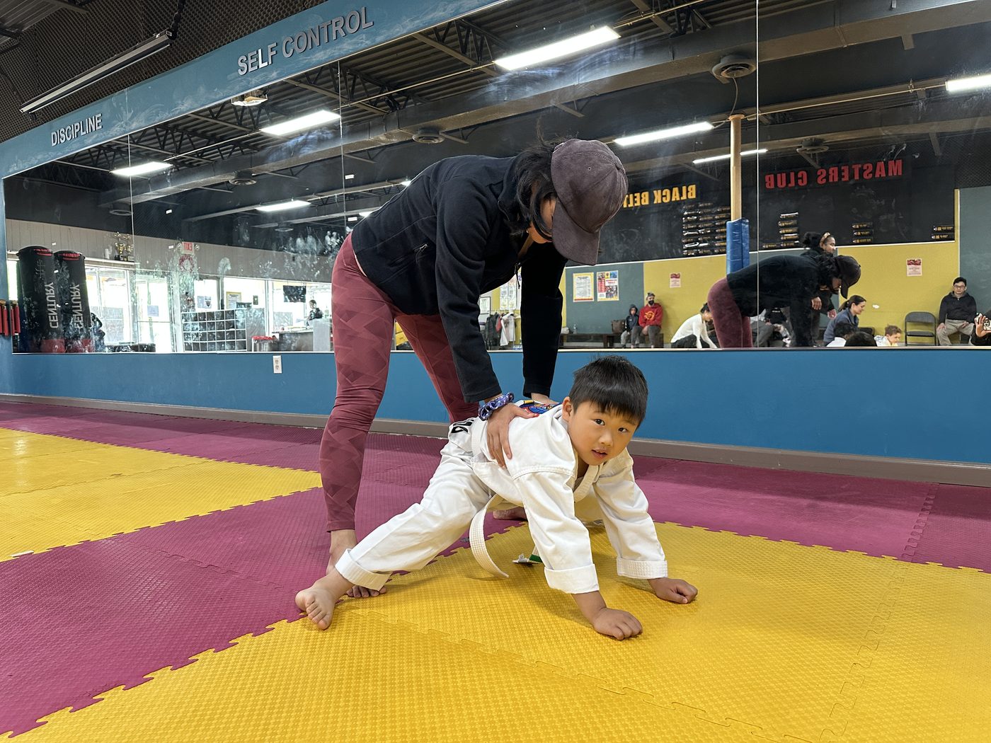Instructor guiding a young student through a movement drill