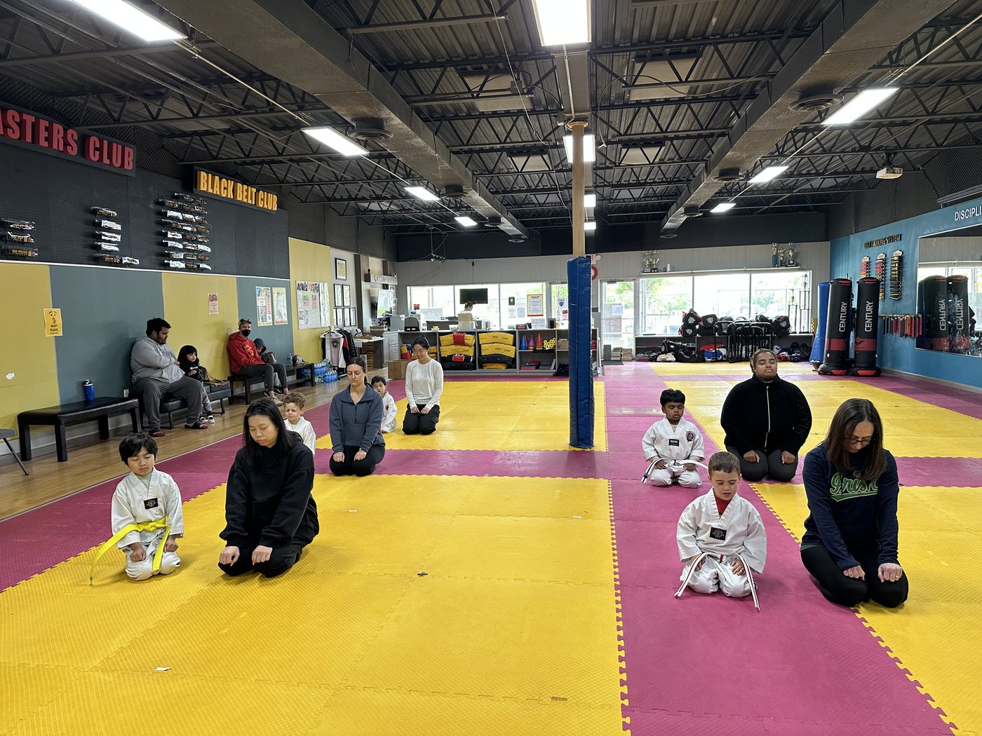 Parents and children meditating together at the start of class