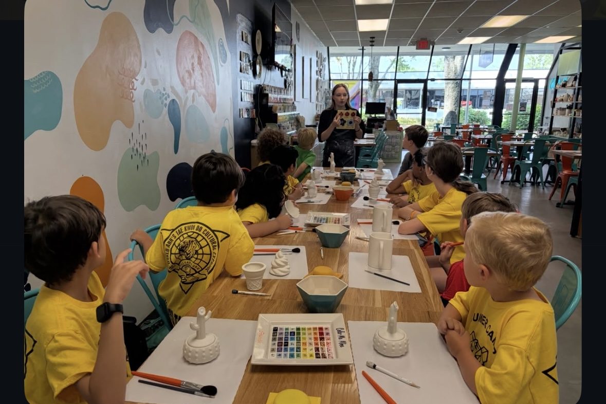 Summer camp students painting ceramics on a field trip