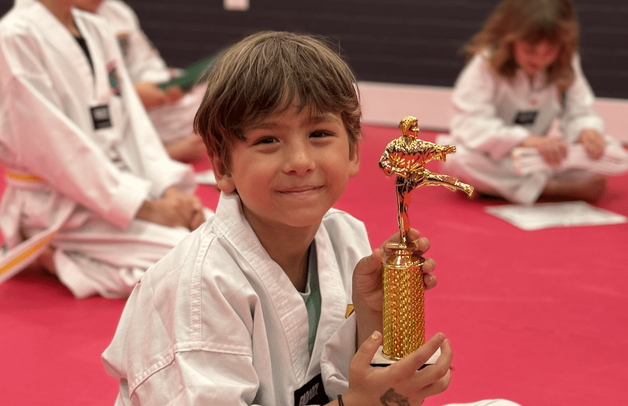Student proudly holding a trophy at Ahn's Taekwondo NYC