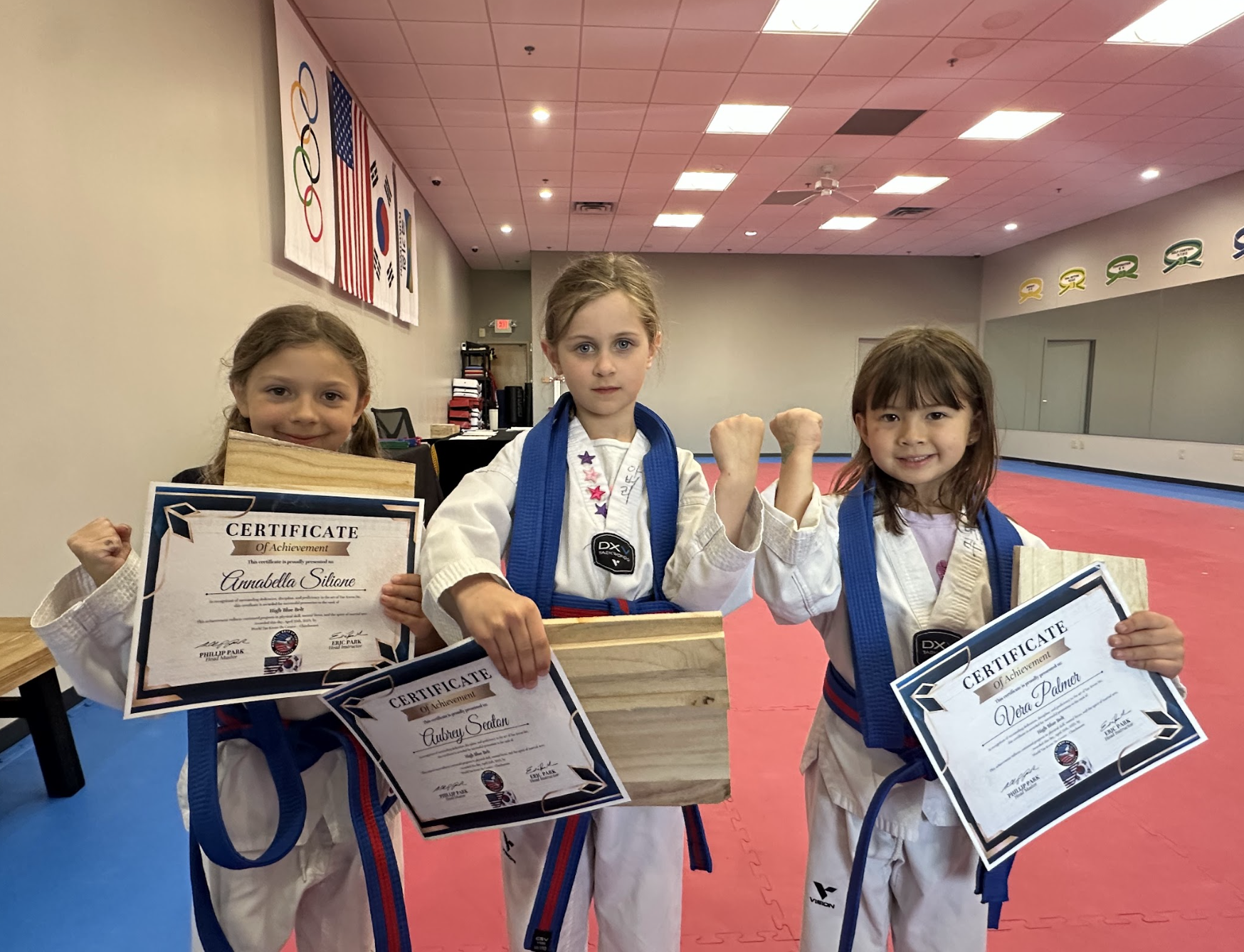 Students with achievement certificates and breaking boards