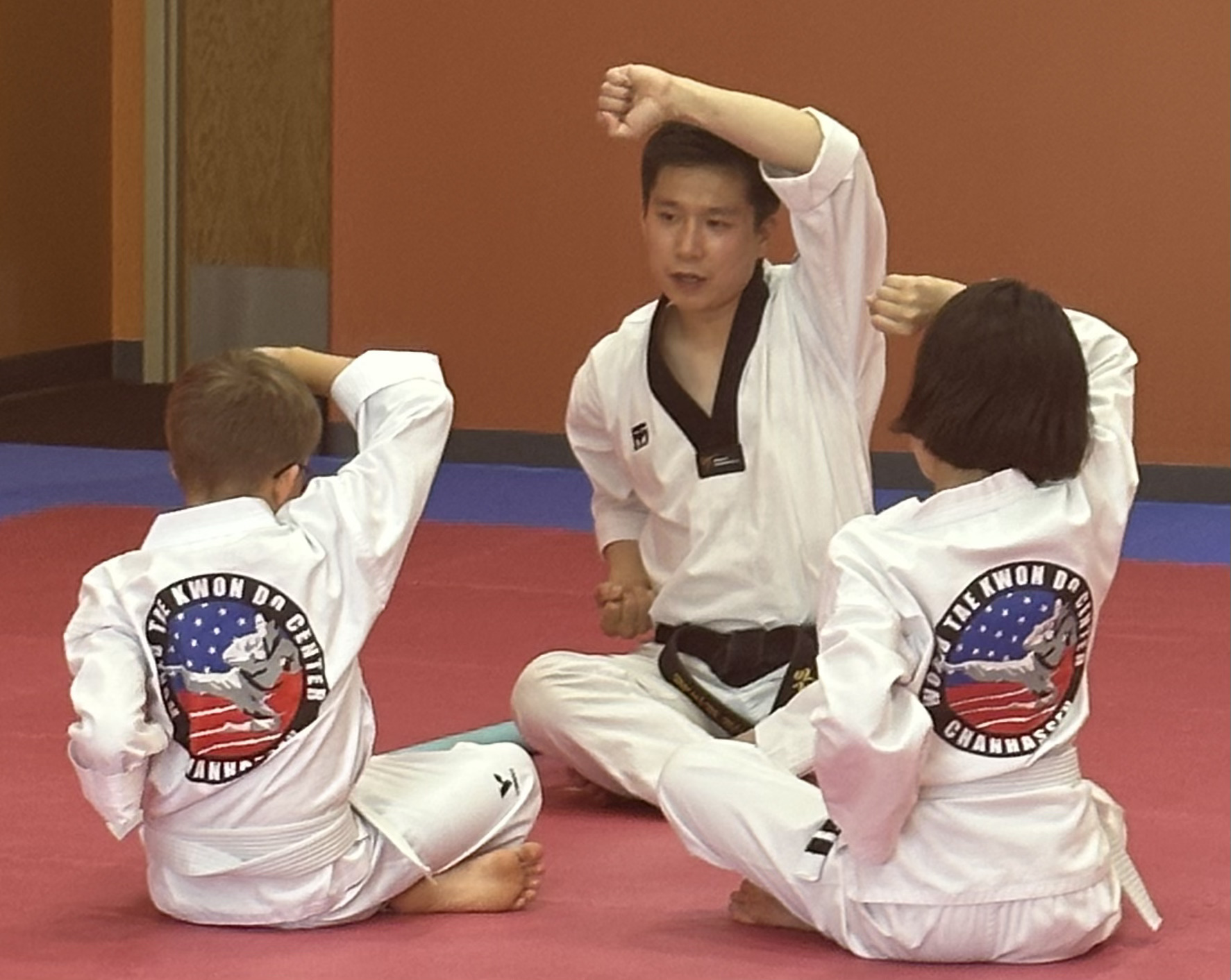 Instructor teaching young students on the mat