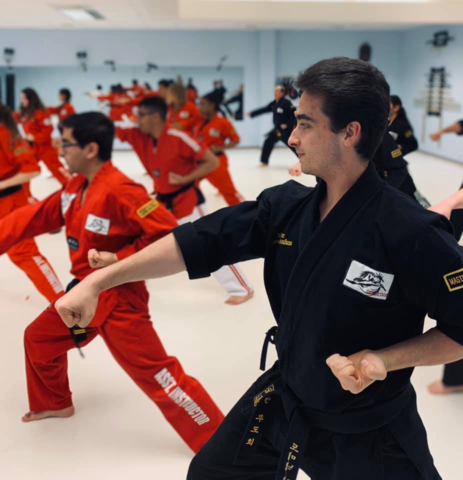 Adult students and masters practicing forms together in training session