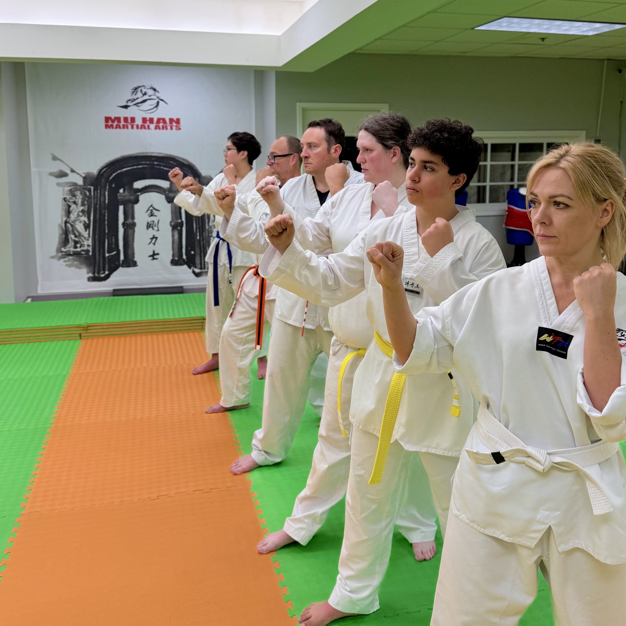 Adult students and masters practicing forms together in training session