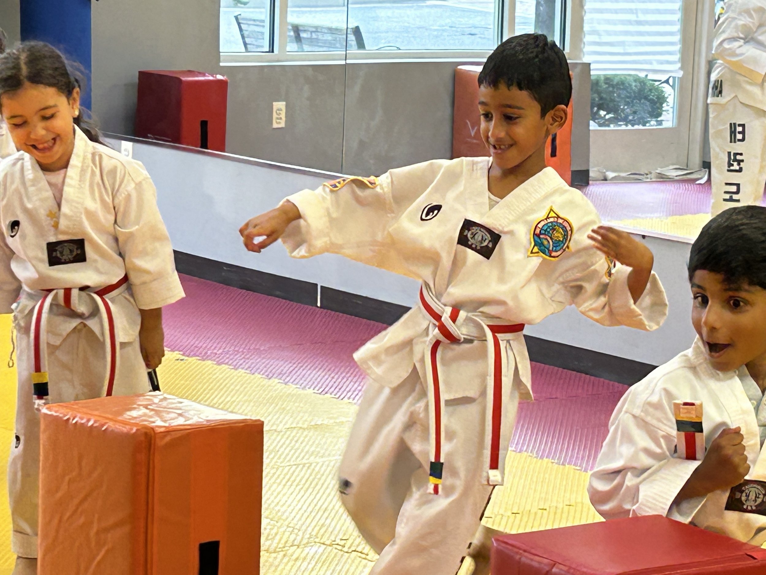 Kids practicing kicks in front of the mirror at the Plainsboro dojang