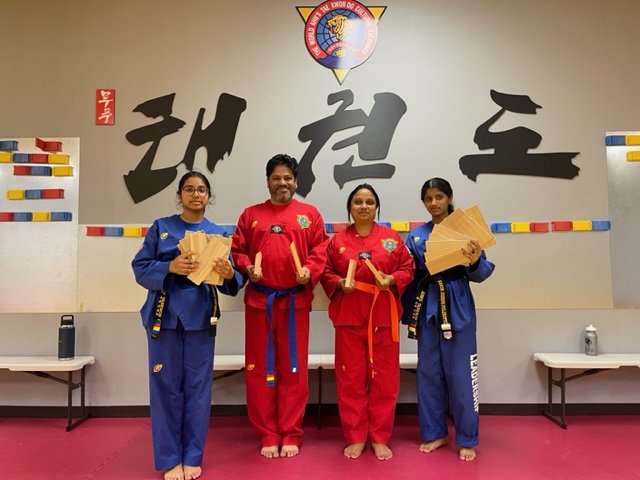 Young students holding breaking boards after class