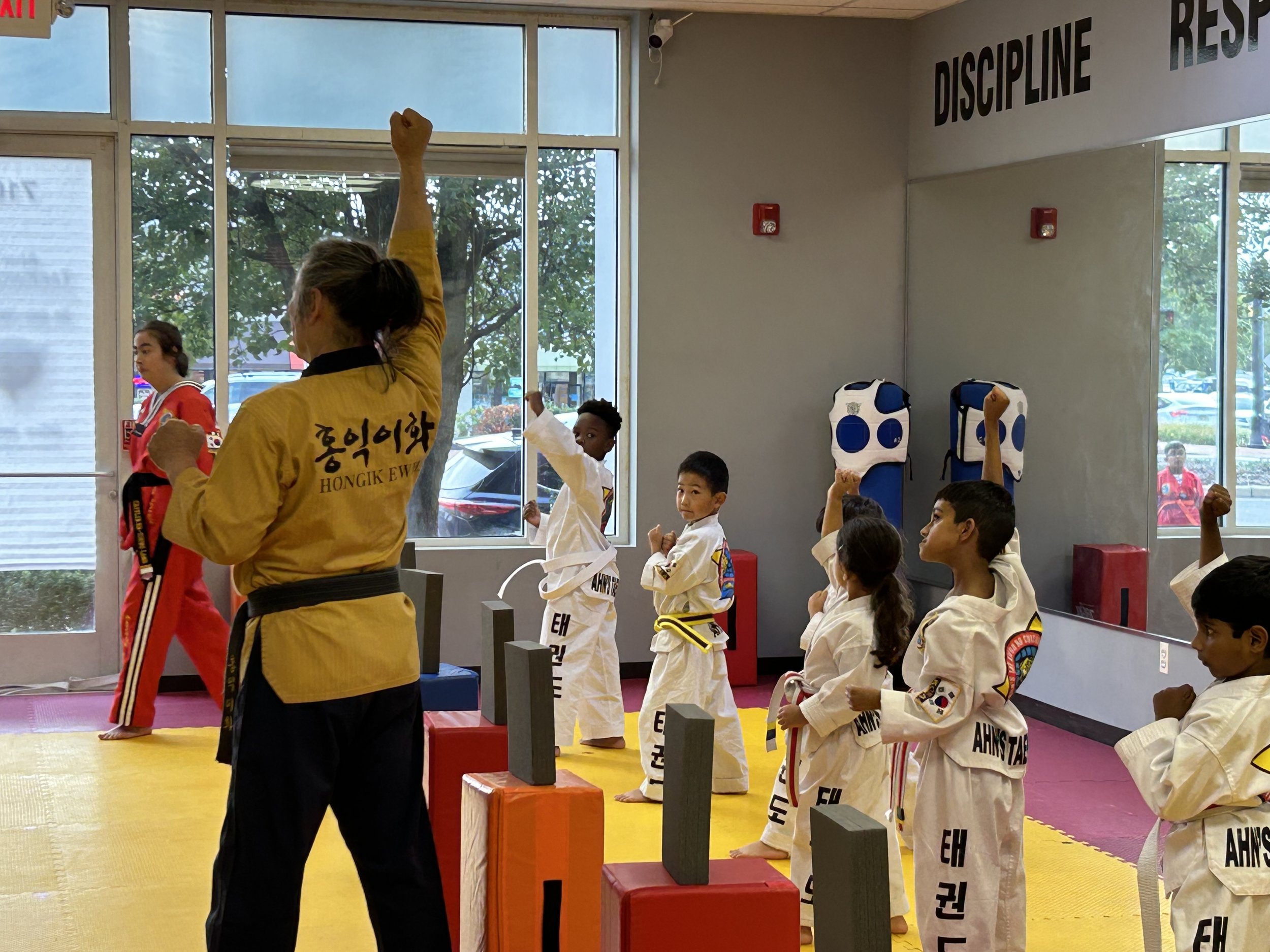 Little Tigers class practicing board breaking with an instructor