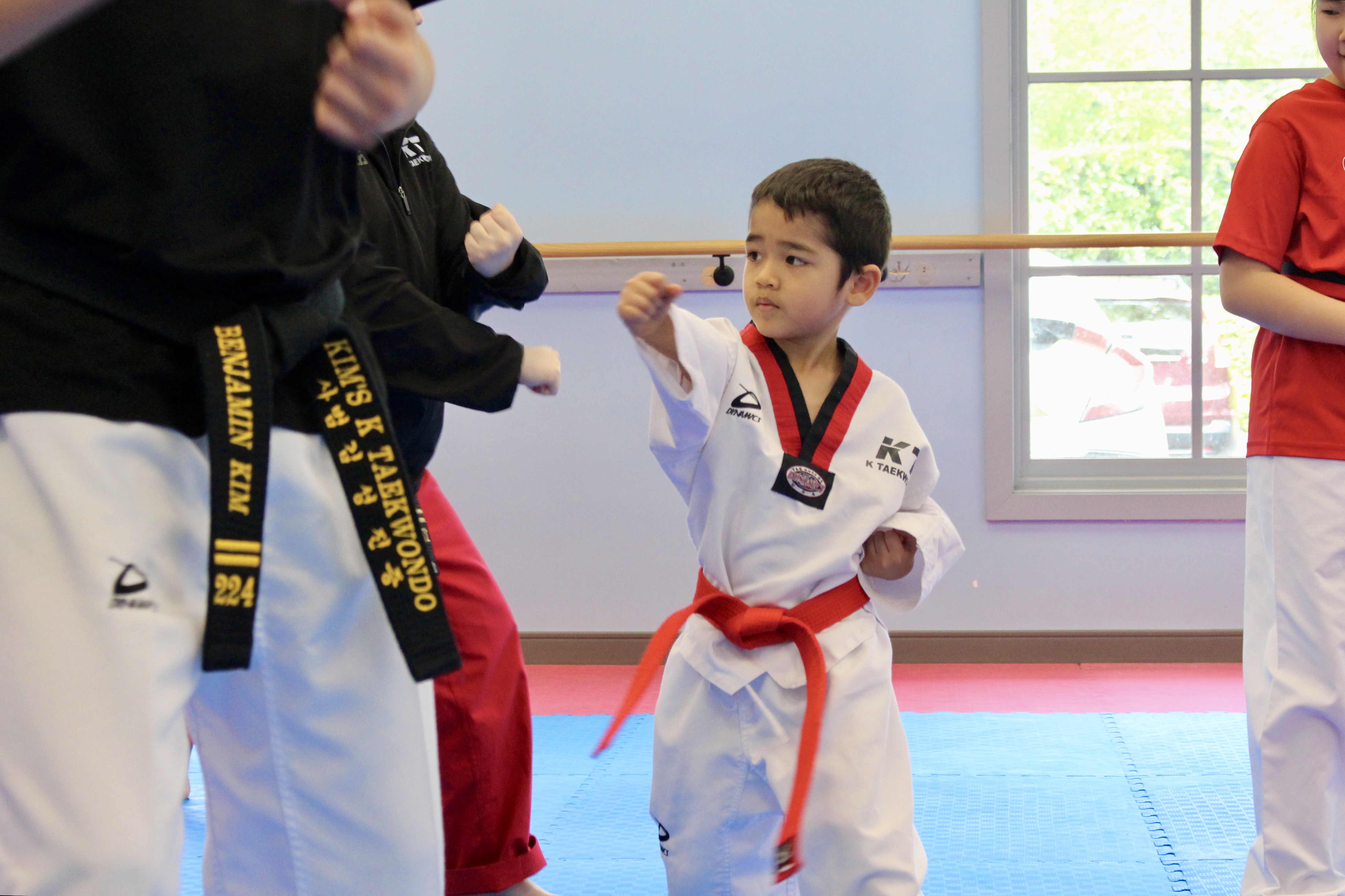 Young student practicing kicks in class
