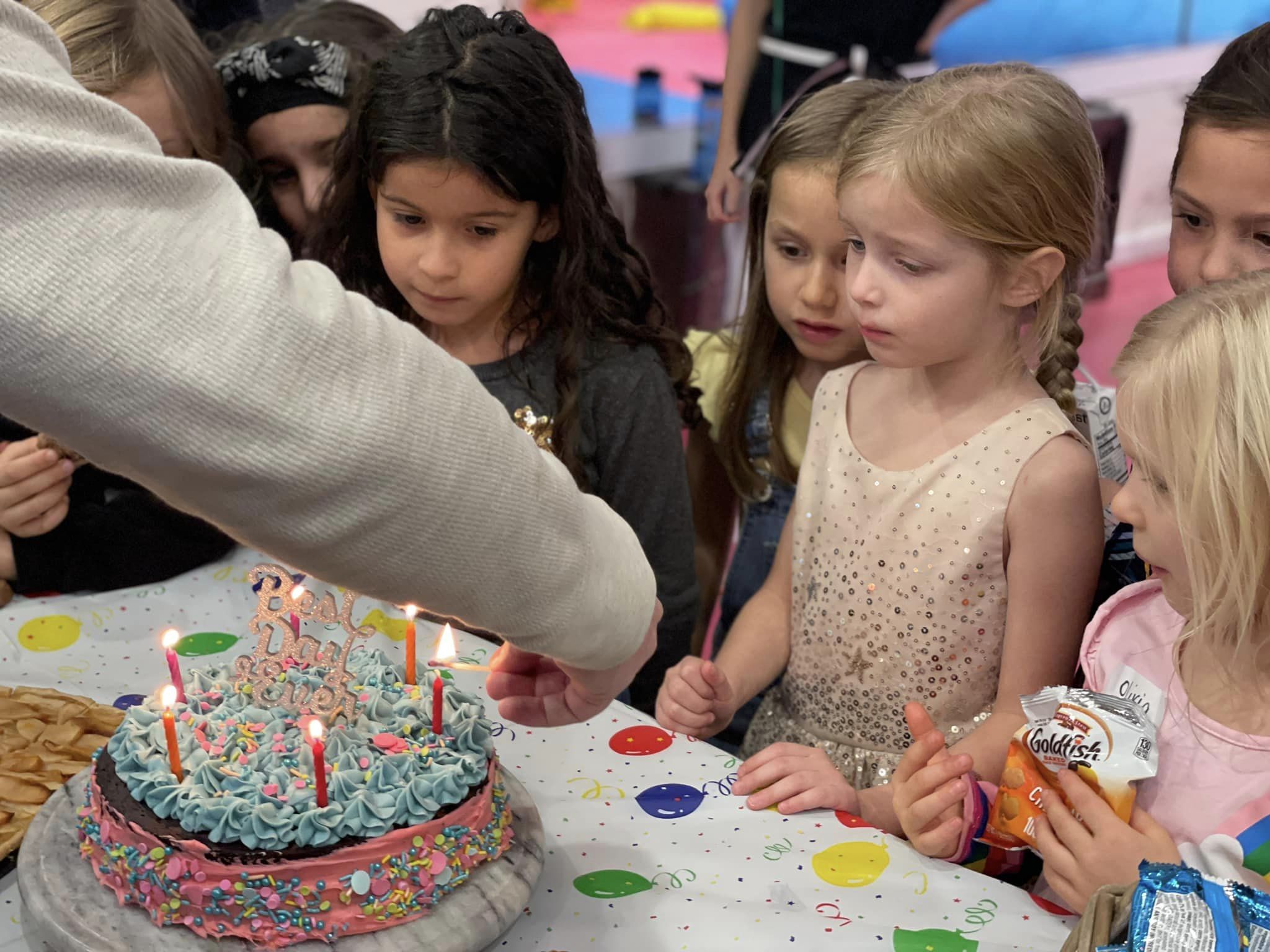 Children gathered around a birthday cake