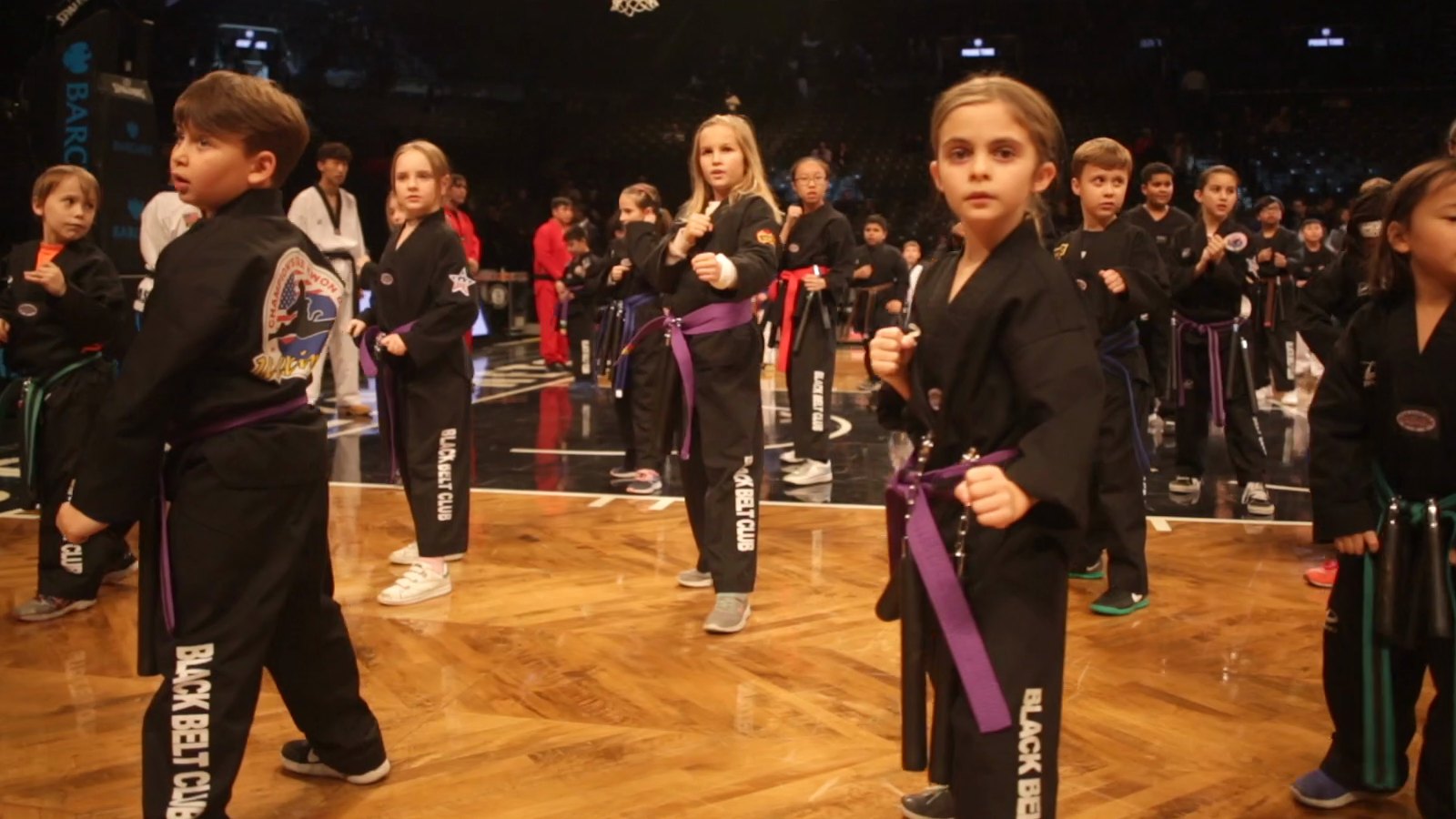 Kids in black uniforms at a Champions Taekwondo event