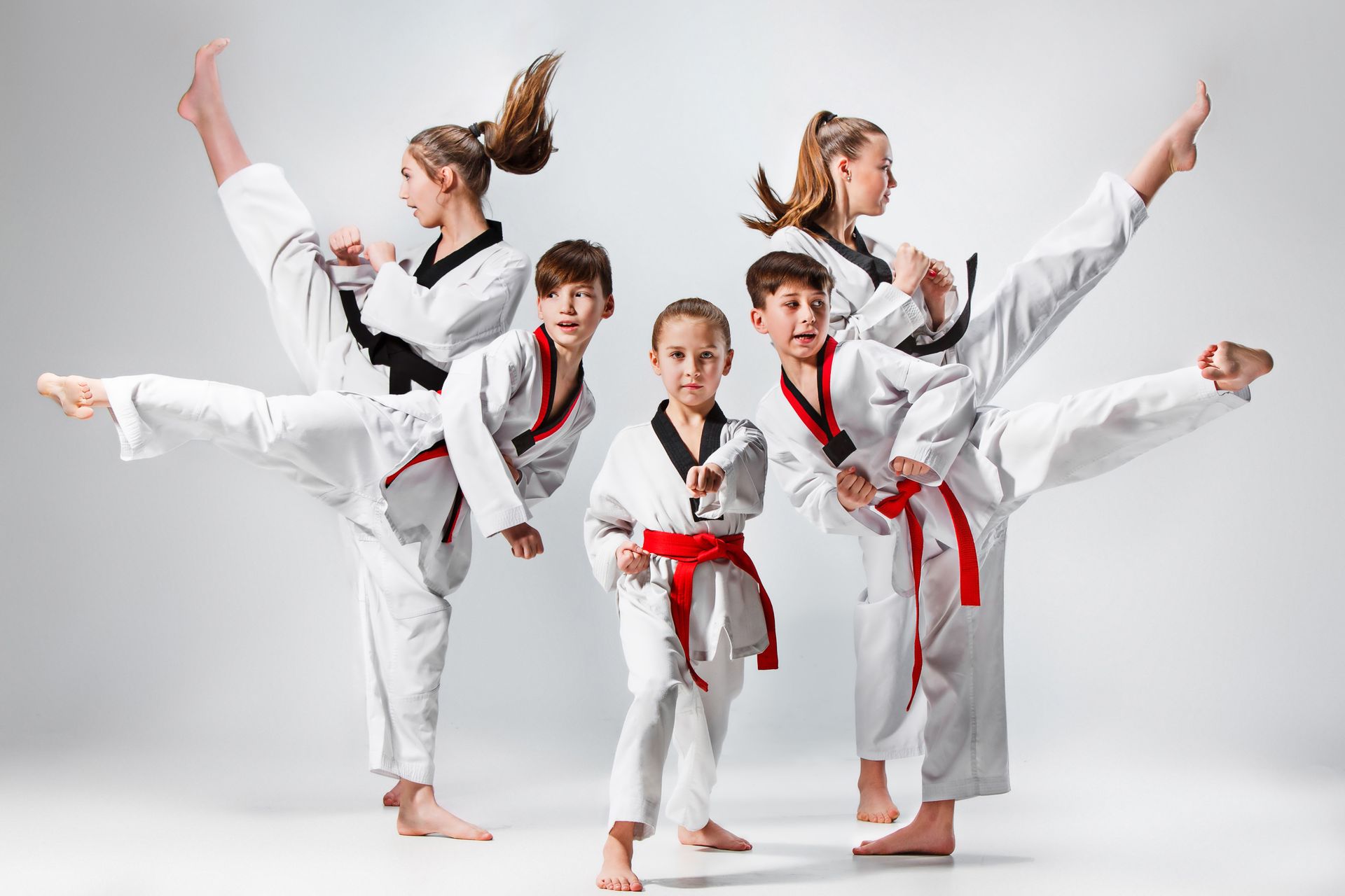 Kids and adults practicing Taekwondo kicks together
