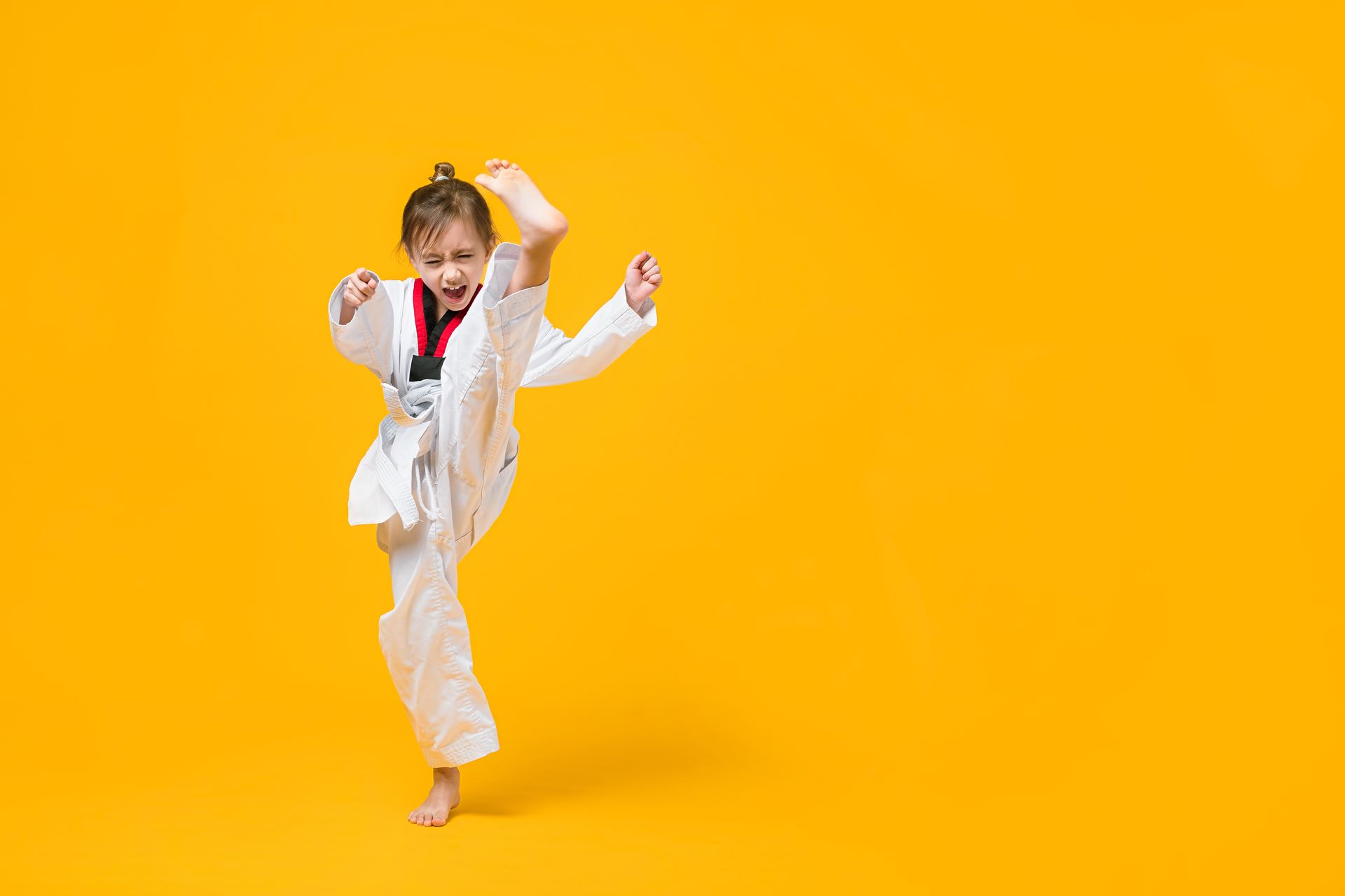 Child in a Taekwondo uniform kicking
